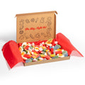 Gift box of assorted sweets and candies with a decorative lid inscribed with a sign, set against a white background.