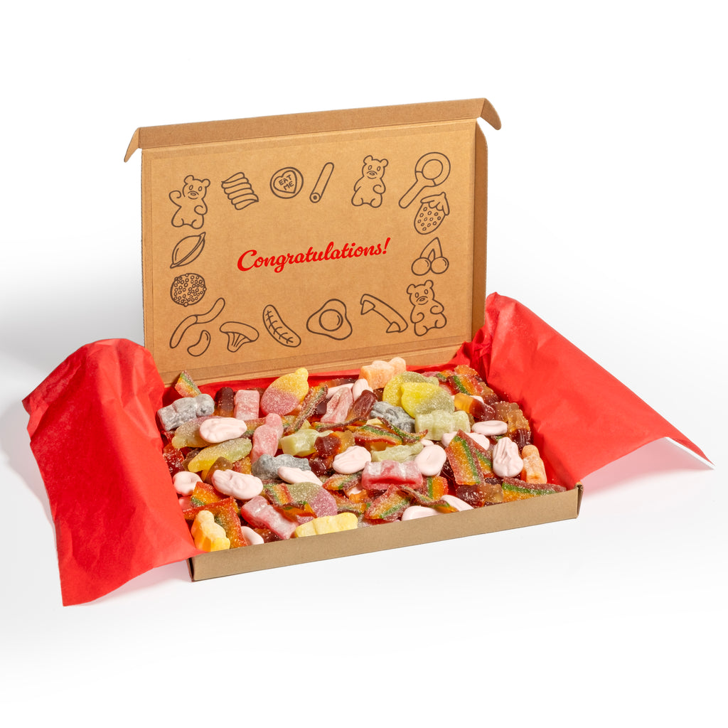 Congratulations gift box of gummy and sour sweets with a decorative lid inscribed with a sign, set against a white background.
